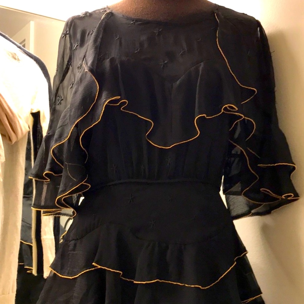 Maison Tallulah black ruffle dress w/ knit star details and gold lining.